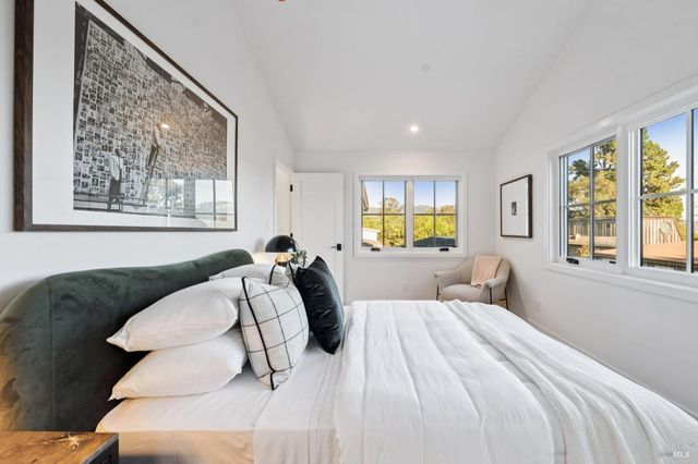 a bed sitting in a bedroom next to a window
