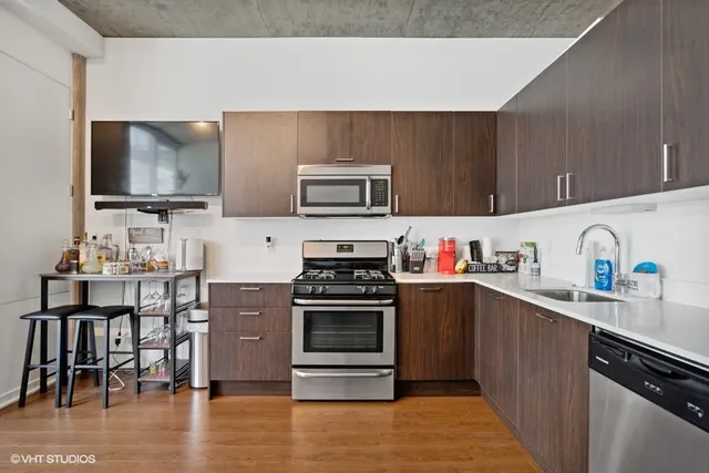 a kitchen with granite countertop a stove top oven microwave and cabinets