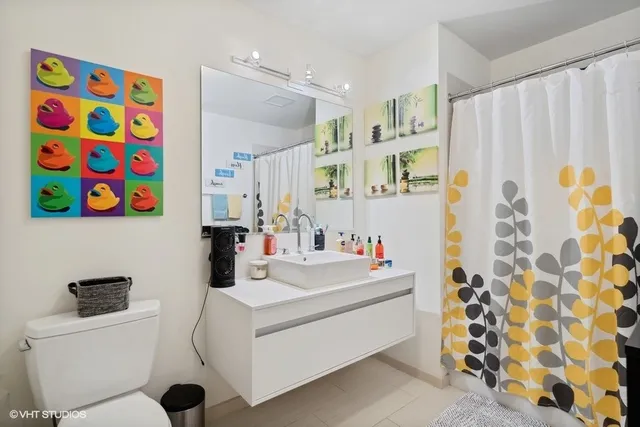 a bathroom with a sink a toilet and a shower curtain