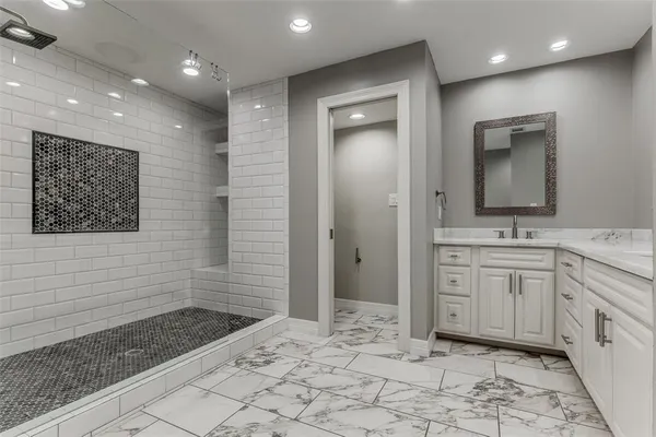 a bathroom with a sink a toilet a large mirror and shower