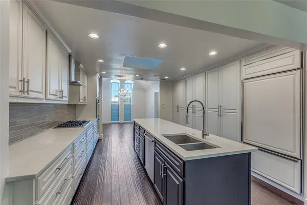a kitchen with granite countertop a sink and a stove top oven