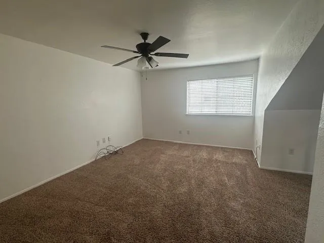 a view of a livingroom with a ceiling fan and window