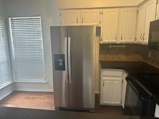 a metallic refrigerator freezer sitting in a kitchen