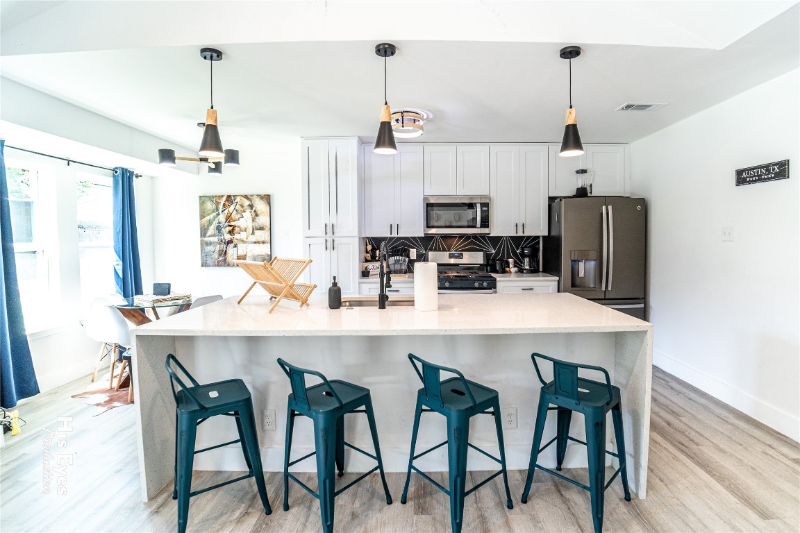 7500 Rio Pass Austin, TX 78724 - Photo 19 of 38 a kitchen with kitchen island a dining table and chairs