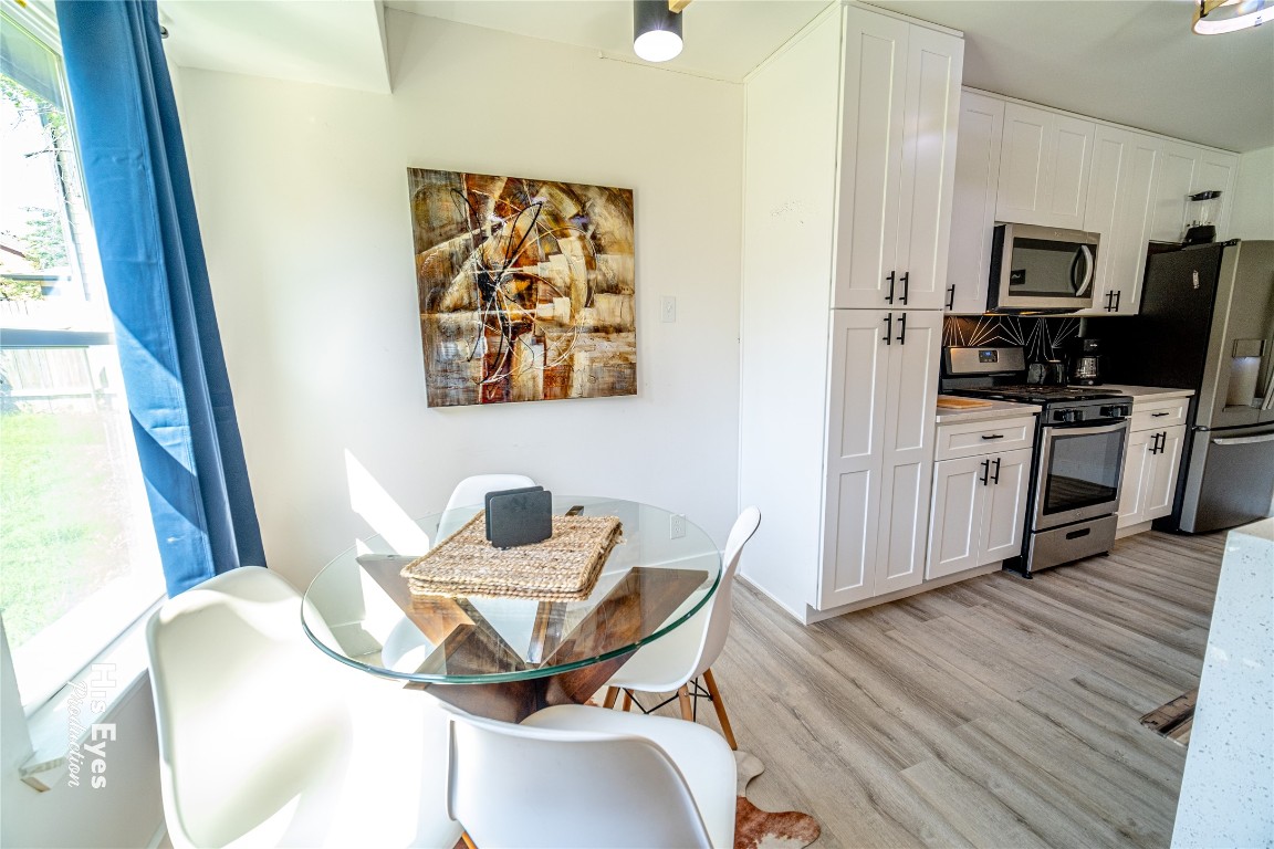 7500 Rio Pass Austin, TX 78724 - Photo 24 of 38 a view of a dining room with furniture a kitchen wooden floor and windows