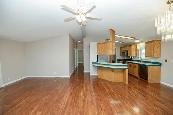 a large kitchen with cabinets wooden floor and stainless steel appliances