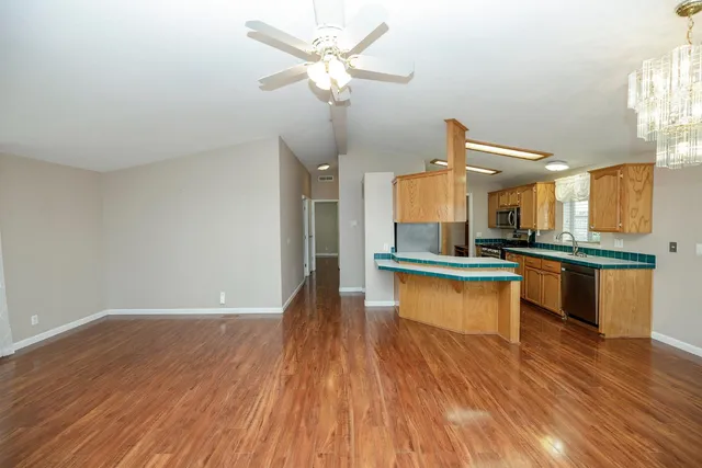 a large kitchen with cabinets wooden floor and stainless steel appliances