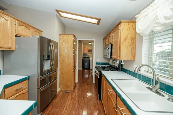 a kitchen with stainless steel appliances granite countertop a sink stove and refrigerator