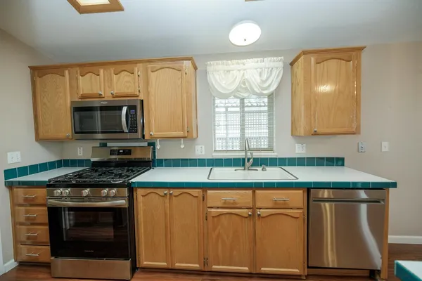 a kitchen with granite countertop a sink and a stove top oven