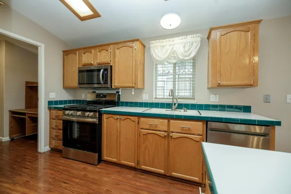 a kitchen with stainless steel appliances a stove a sink and a microwave