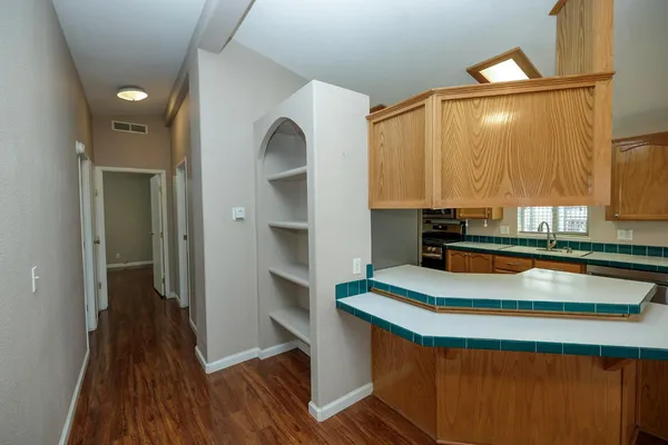 a kitchen with kitchen island granite countertop a sink cabinets and wooden floor