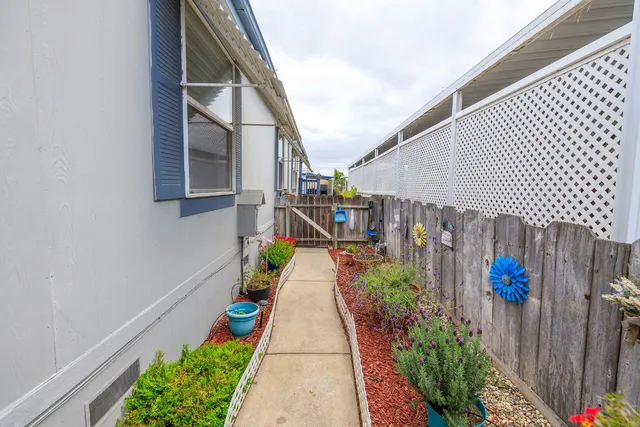 a view of a pathway of a house with a flower garden
