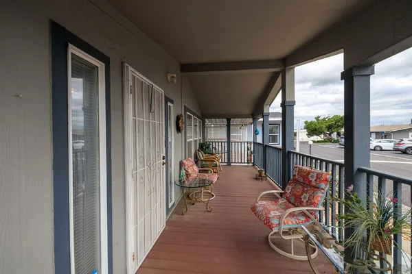 a view of a hallway with wooden floor and furniture