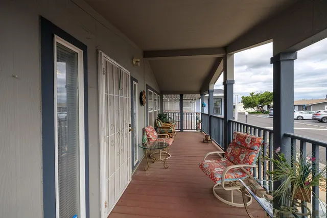 a view of a hallway with wooden floor and furniture