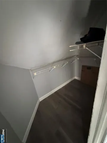 a view of walk in closet with empty racks