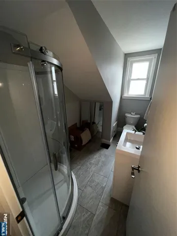 a bedroom with a bed a mirror and night stand