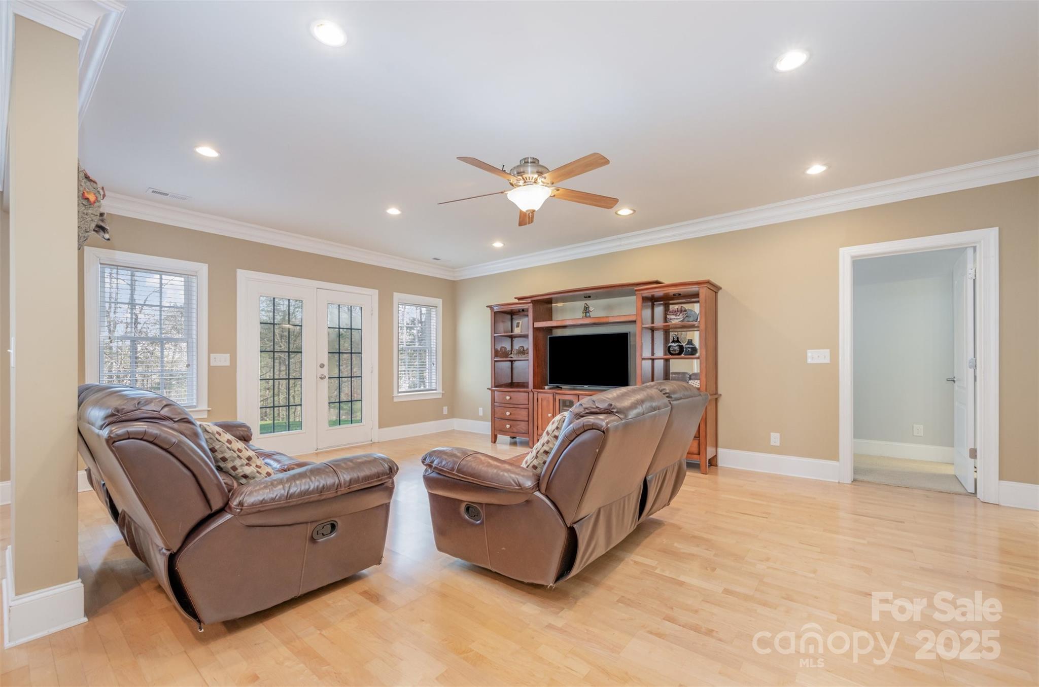 9467 Hester Court Harrisburg, NC 28075 - Photo 33 of 48 a living room with furniture ceiling fan and a flat screen tv