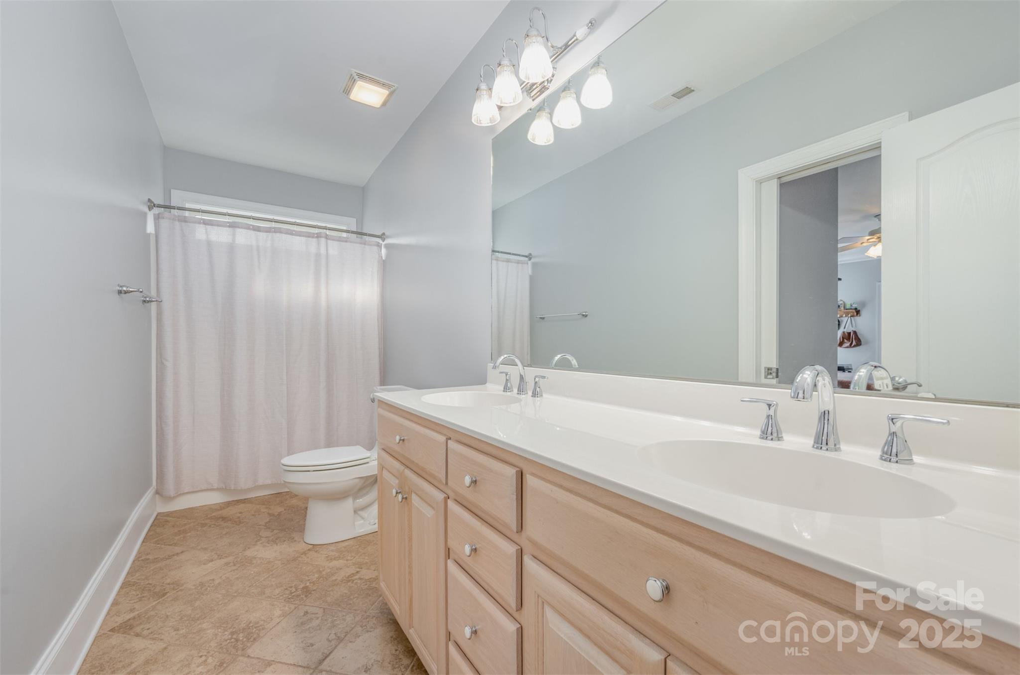 9467 Hester Court Harrisburg, NC 28075 - Photo 35 of 48 a bathroom with a sink a toilet and a large mirror