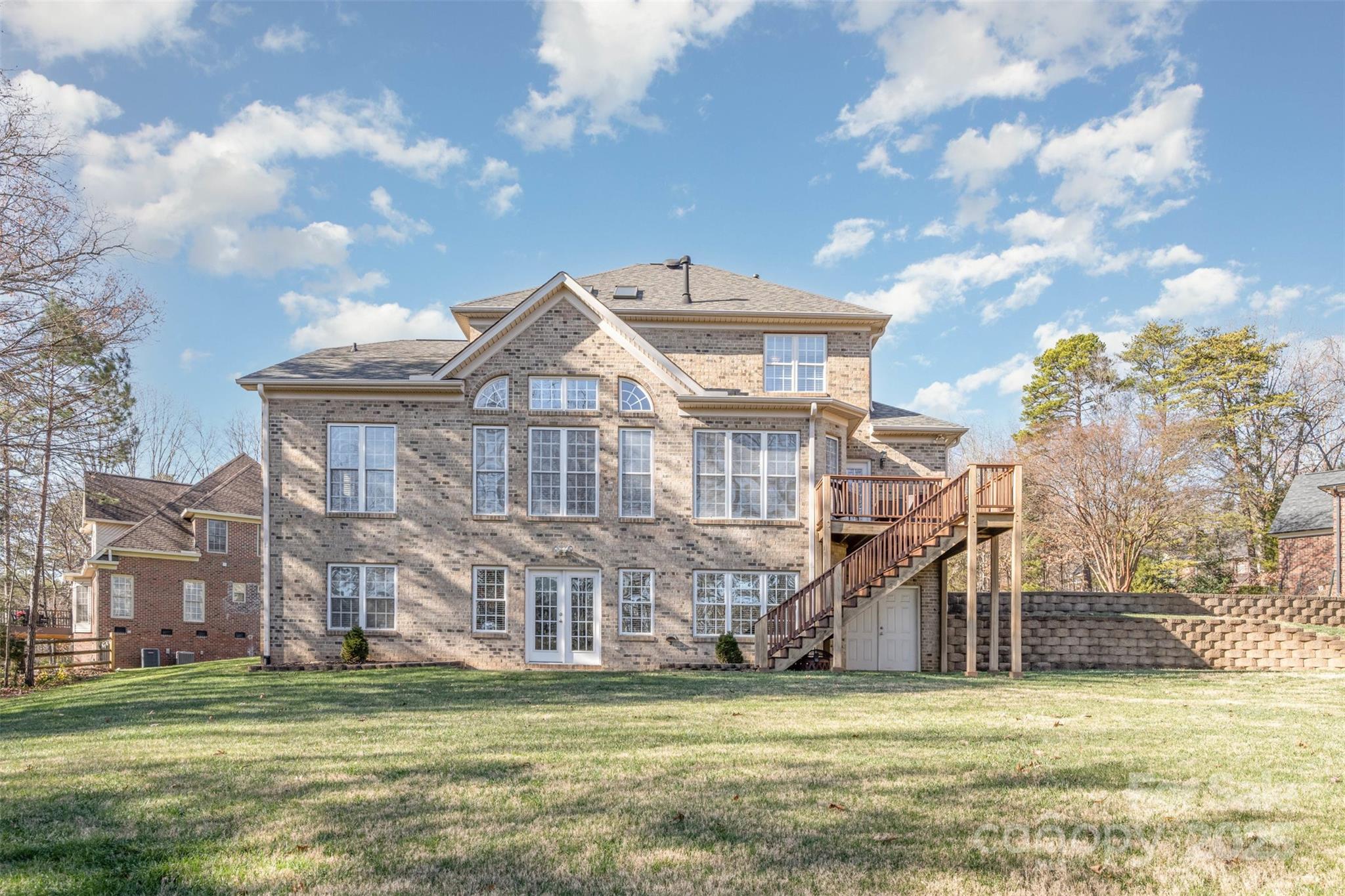 9467 Hester Court Harrisburg, NC 28075 - Photo 44 of 48 a view of a big building next to a big yard with large trees