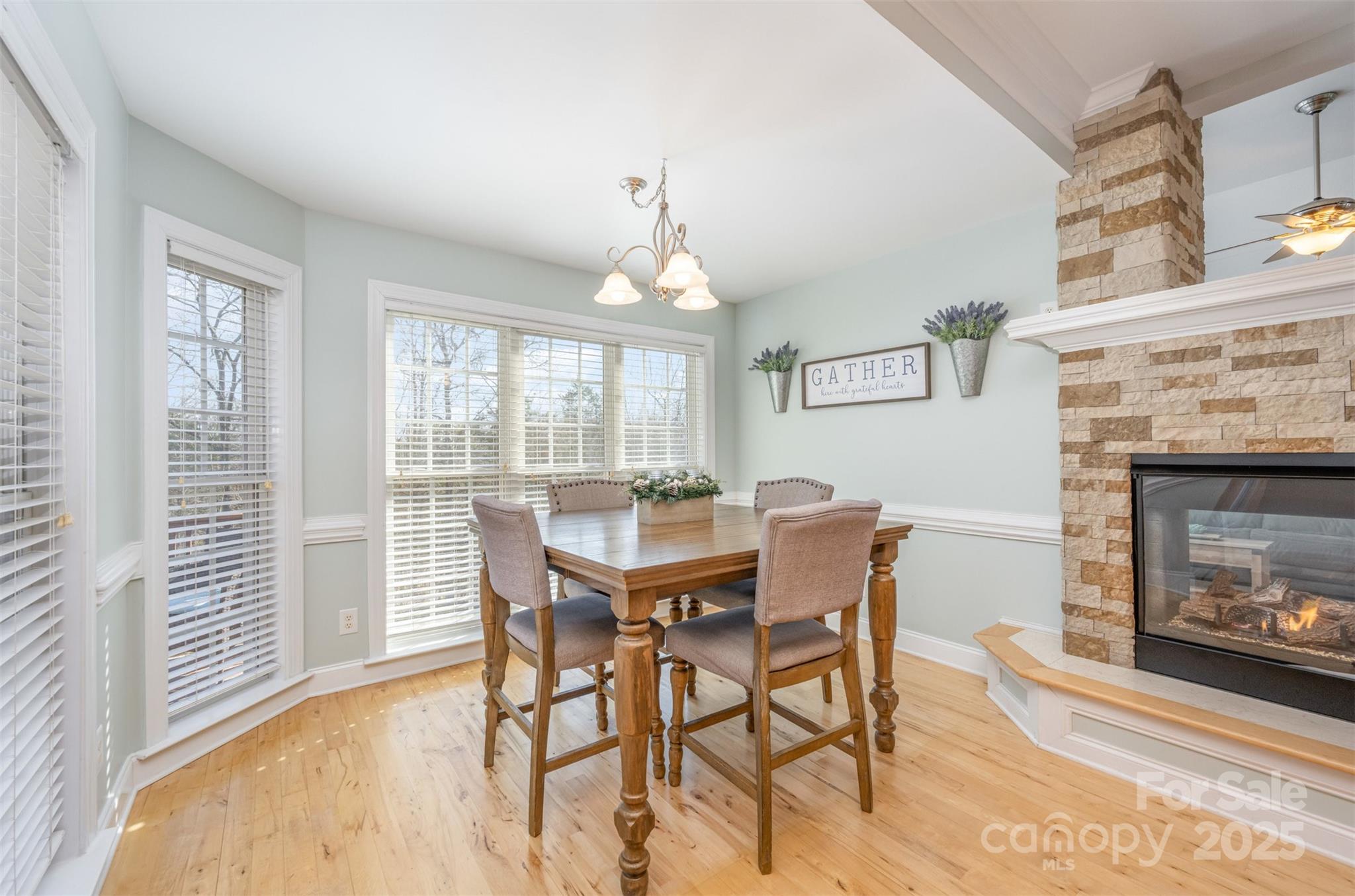 9467 Hester Court Harrisburg, NC 28075 - Photo 7 of 48 a dining room with furniture a fireplace and wooden floor