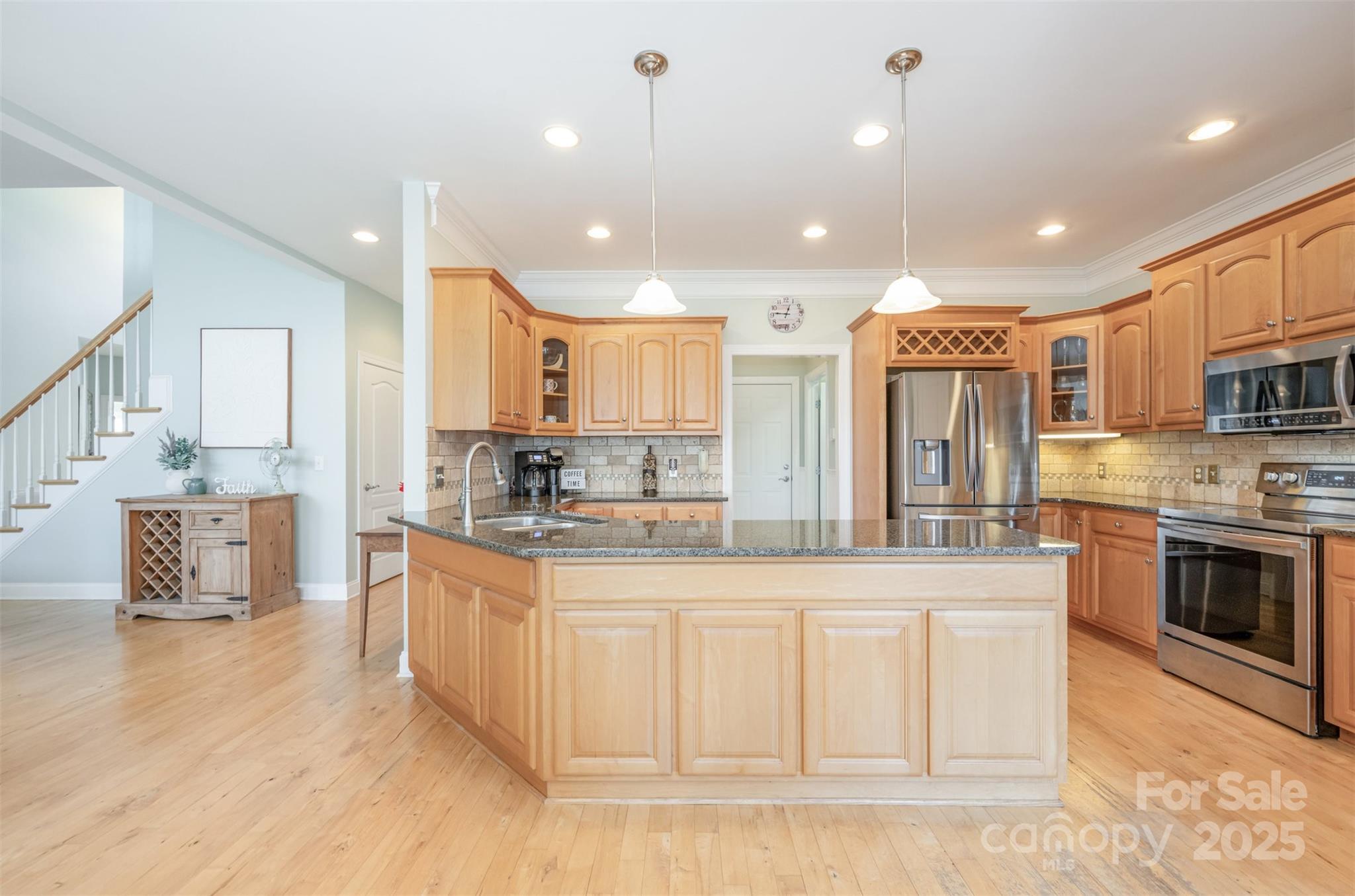 9467 Hester Court Harrisburg, NC 28075 - Photo 9 of 48 a large kitchen with stainless steel appliances kitchen island granite countertop a large stove a sink a refrigerator and white cabinets with wooden floor