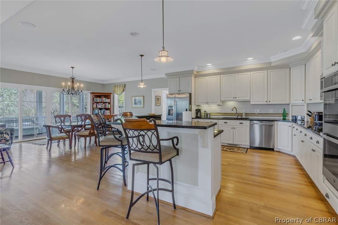 507 Sunnybank Road Reedville, VA 22539 - Photo 25 of 48 Kitchen with a kitchen island, tasteful backsplash, stainless steel appliances, light hardwood / wood-style flooring, and pendant lighting