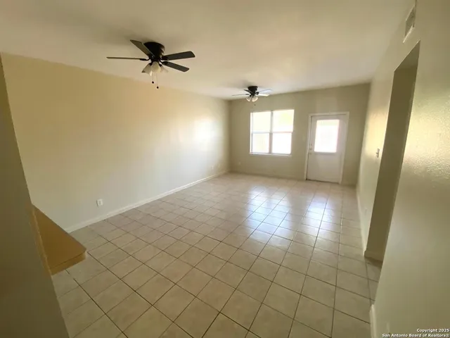 a view of a room with a window and a ceiling fan
