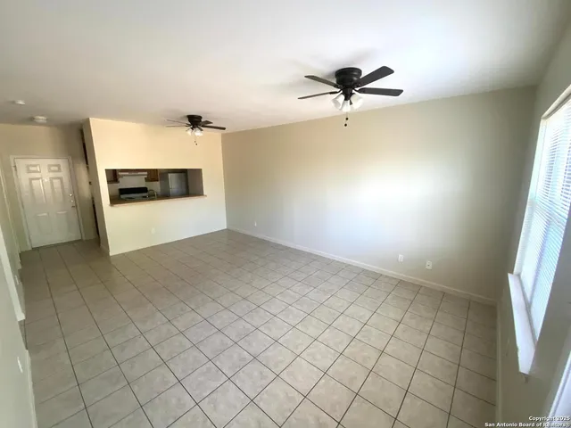 a view of a livingroom with a ceiling fan and window