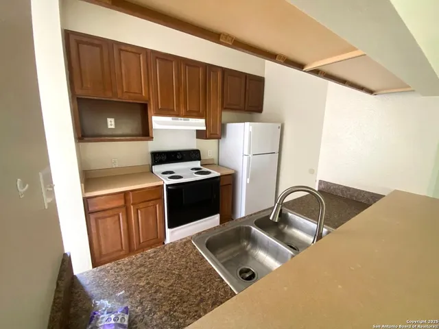 a kitchen with a sink a stove and a refrigerator