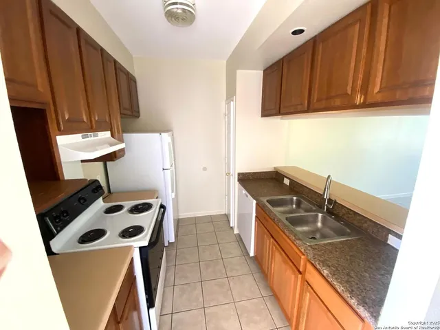 a kitchen with a sink a stove and a refrigerator