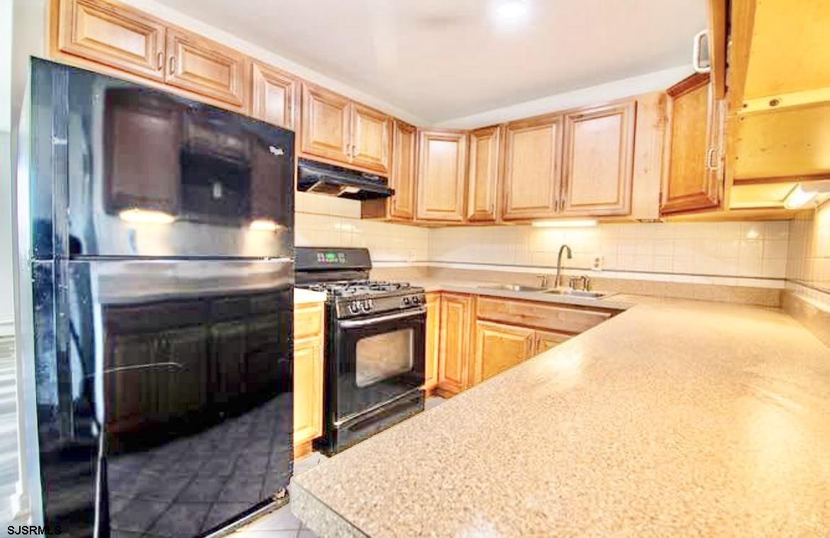 4901 Harbor Beach Boulevard, Unit N10 Brigantine, NJ 08203 - Photo 2 of 17 a kitchen with stainless steel appliances granite countertop a stove a sink and a microwave