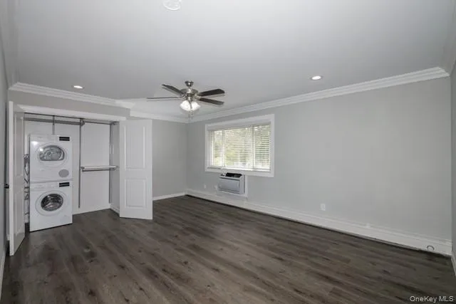 a view of an empty room with wooden floor and window