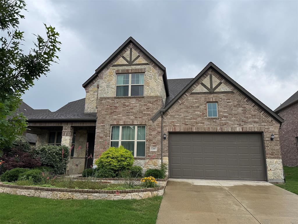 View of front facade featuring concrete driveway, brick siding, stone siding, a garage, and a front lawn