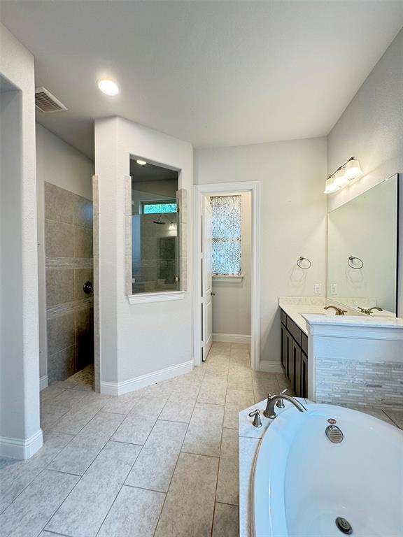12407 Scottswood Road Frisco, TX 75035 - Photo 9 of 14 Full bathroom featuring vanity, a walk in shower, a bath, and light tile patterned floors