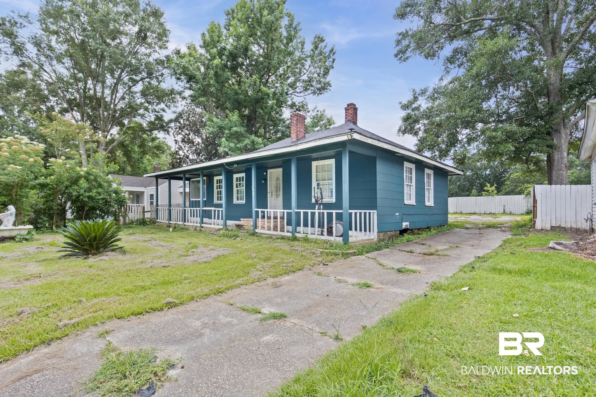 160 Glenn Avenue Mobile, AL 36606 - Photo 2 of 15 Blue siding exterior with white trim, a covered front porch, white porch railings, and a side driveway