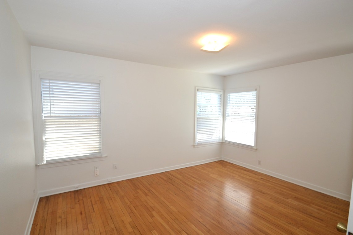 1211 Ridgemont Drive Austin, TX 78723 - Photo 16 of 28 a view of an empty room with wooden floor and a window