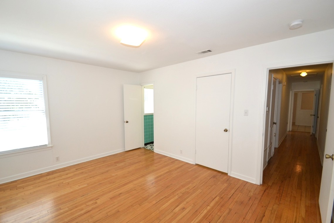 1211 Ridgemont Drive Austin, TX 78723 - Photo 19 of 28 a view of an empty room with wooden floor and a window
