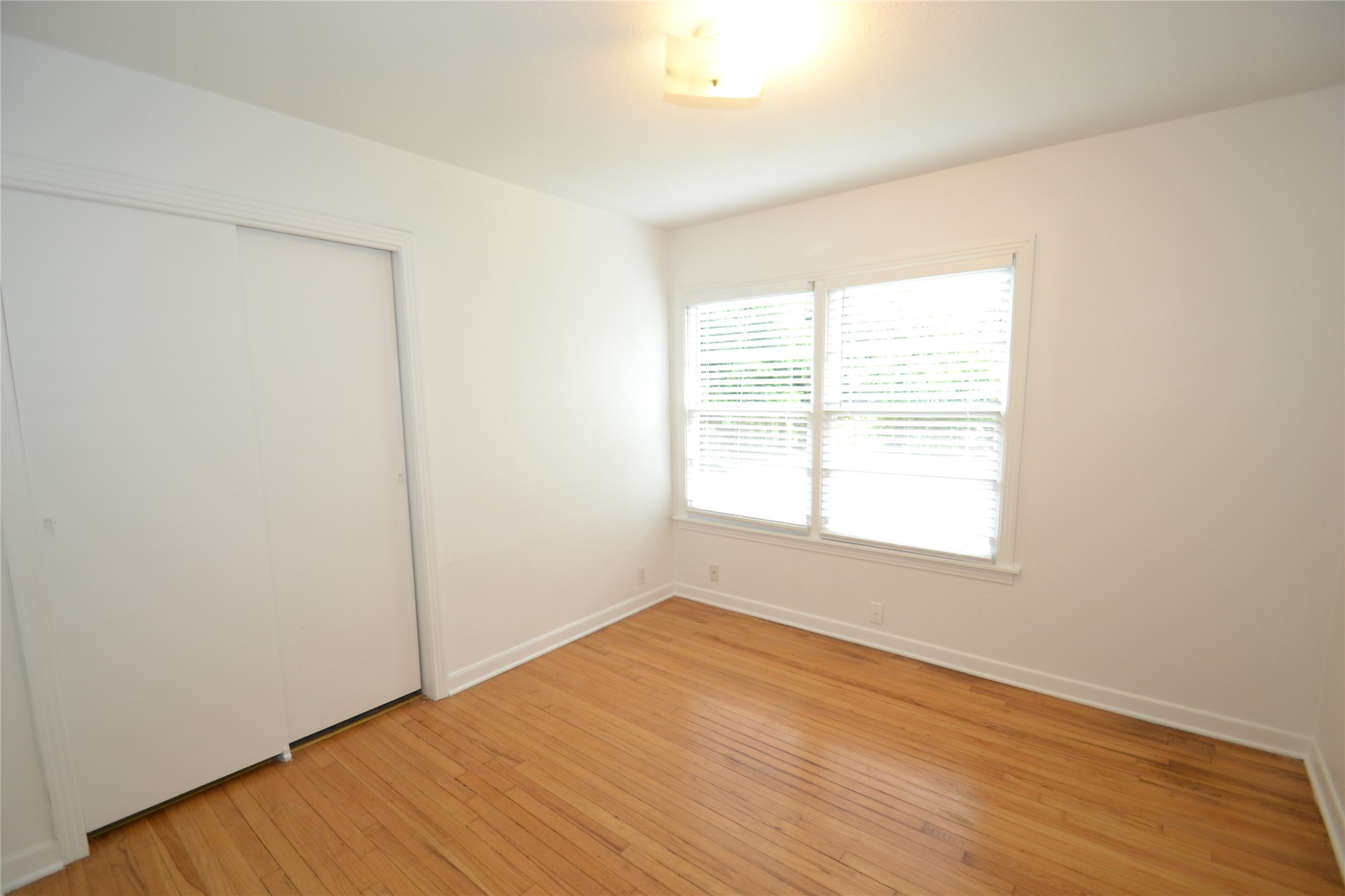 1211 Ridgemont Drive Austin, TX 78723 - Photo 21 of 28 an empty room with wooden floor and windows