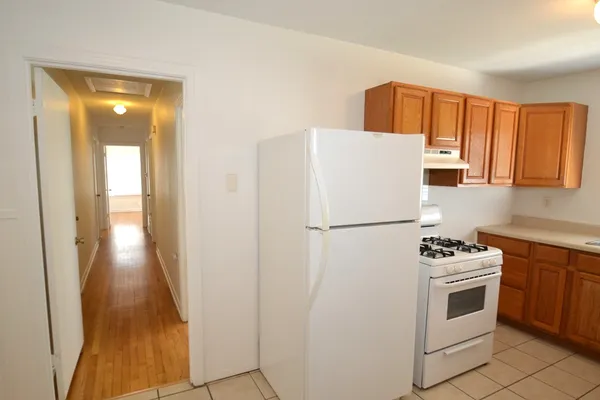 a white refrigerator freezer and a stove sitting inside of a kitchen