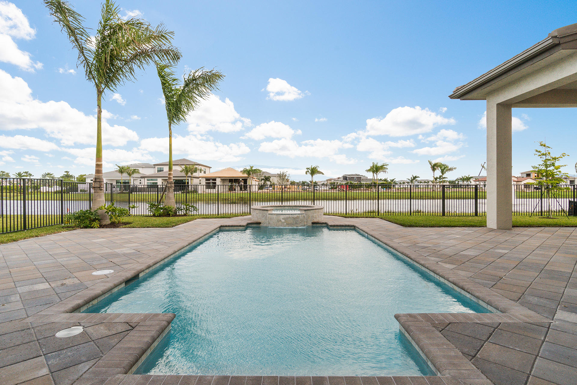 17334 Rosella Road Boca Raton, FL 33496 - Photo 42 of 50 a view of a swimming pool with a lawn chairs and a palm tree