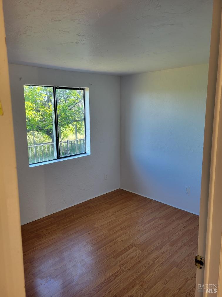 7630 Walnut Lane Lower Lake, CA 95457 - Photo 8 of 11 an empty room with wooden floor and windows
