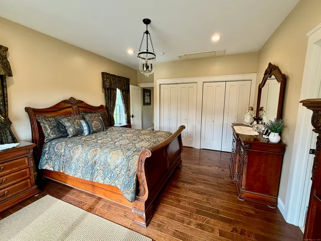 a large bedroom with bed and wooden floor