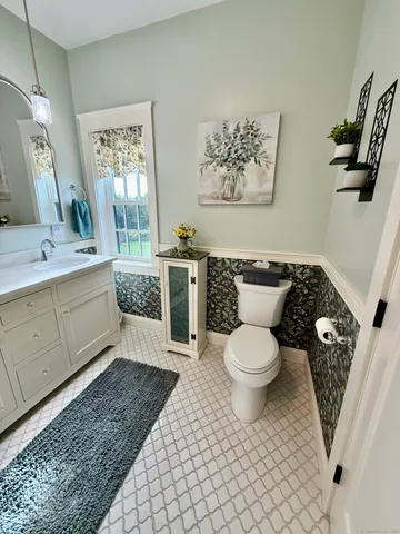 a bathroom with a toilet a sink and mirror