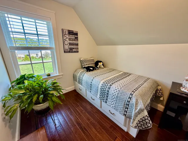 a bed sitting in a bedroom next to a window