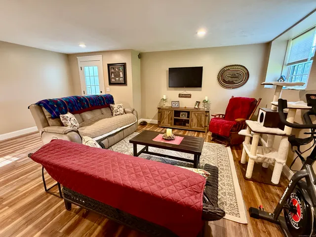 a living room with furniture a flat screen tv and a fireplace