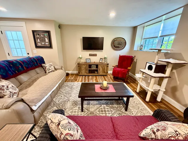 a living room with furniture a rug and a flat screen tv