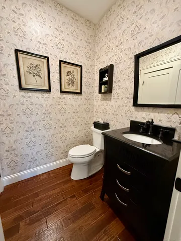 a bathroom with a toilet sink vanity and mirror