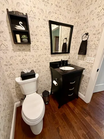 a bathroom with a toilet sink and mirror