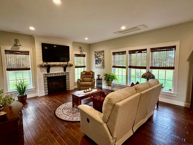 a living room with furniture a flat screen tv and a fireplace