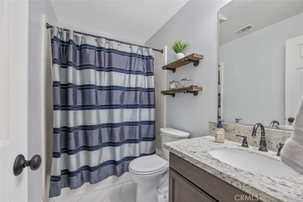 30177 Sagecrest Way Castaic, CA 91384 - Photo 33 of 54 a bathroom with a granite countertop sink a toilet and shower